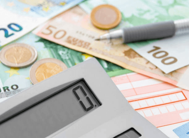 Personne montant son dossier de financement de formation devant un ordinateur avec une calculatrice